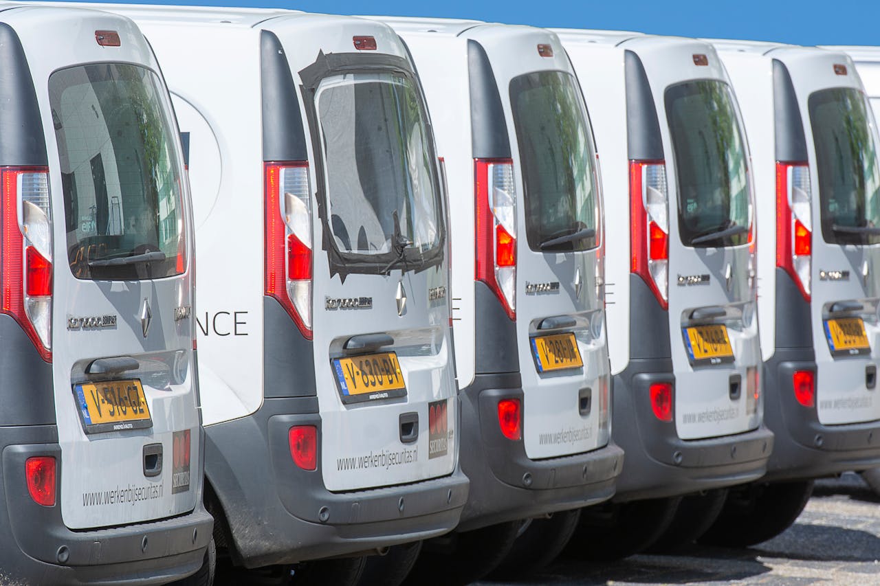 about-bg A row of white delivery vans parked outdoors, showcasing uniformity and logistics.
