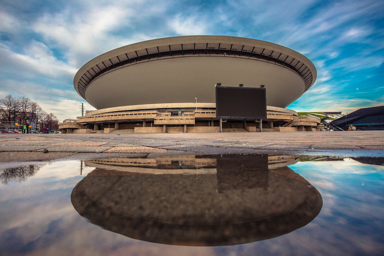 our-story A stunning view of the Spodek Arena in Katowice, Poland, reflecting in a puddle.