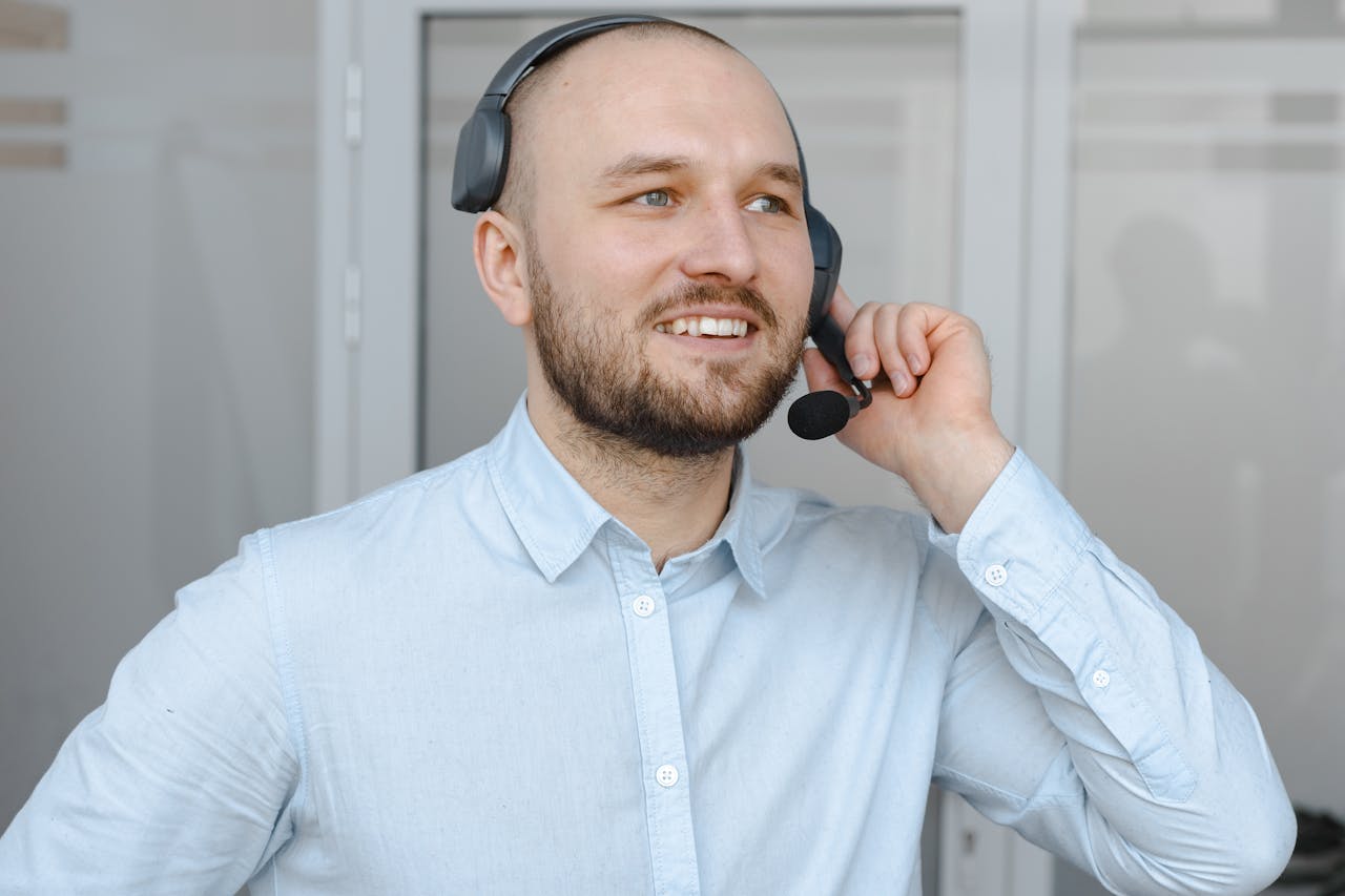 services-04 Smiling call center agent wearing a headset providing customer service in an office environment.